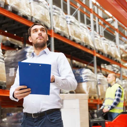 Man holding clipboard in warehouse